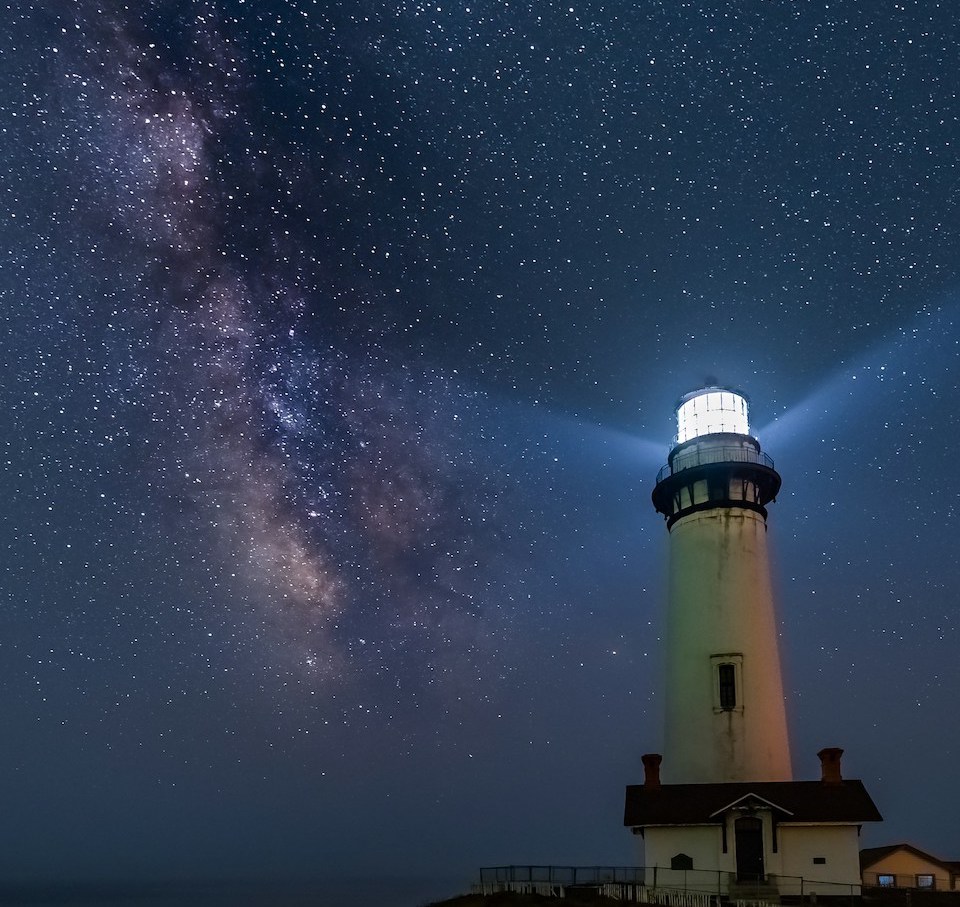 Photograph of a lighthouse at night against a starry sky, photo by Zetong Li