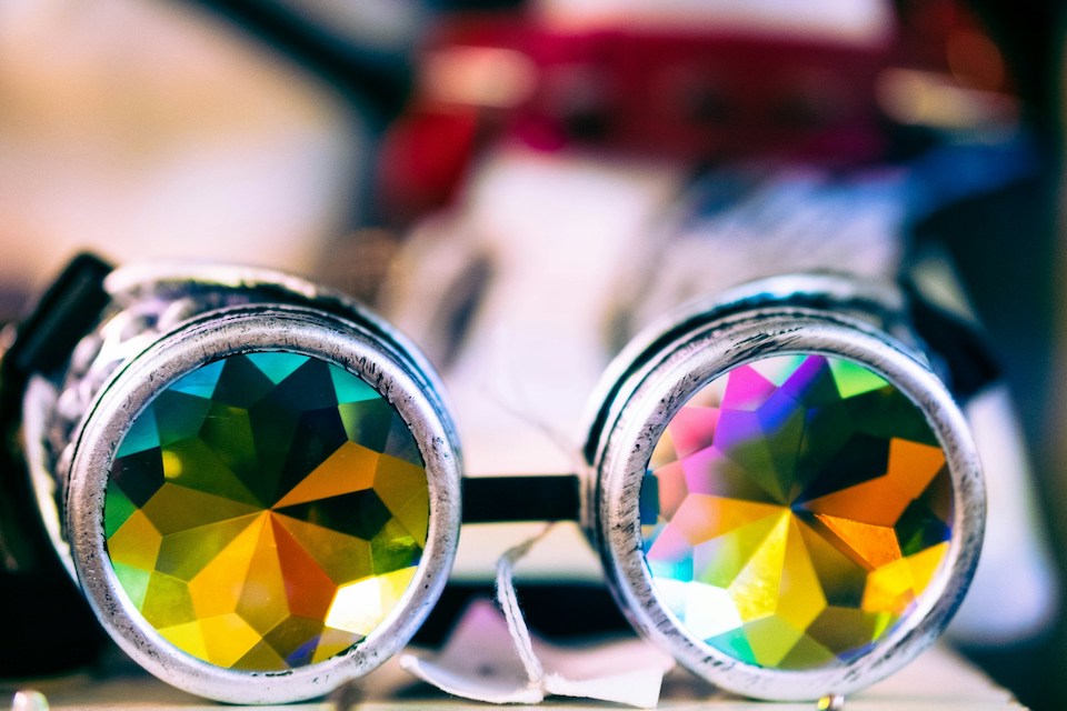 Photo of a pair of glasses with very colourful kaleidoscope-like lenses, photo by Malcolm Lightbody